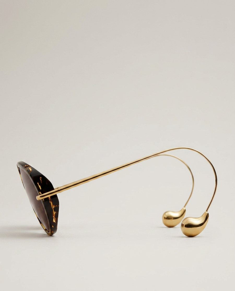 Side view of the same sunglasses showing the thin gold arm sweeping back to a polished gold drop