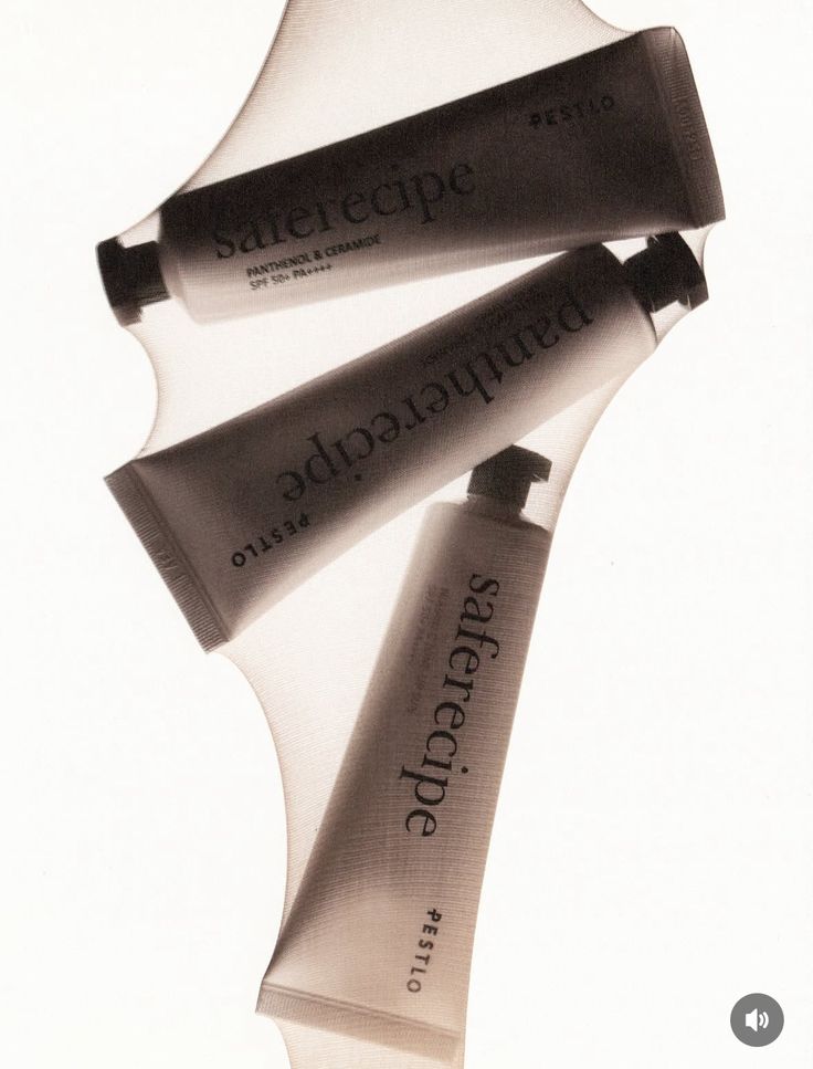 Three skincare tubes visible through backlit translucent fabric.