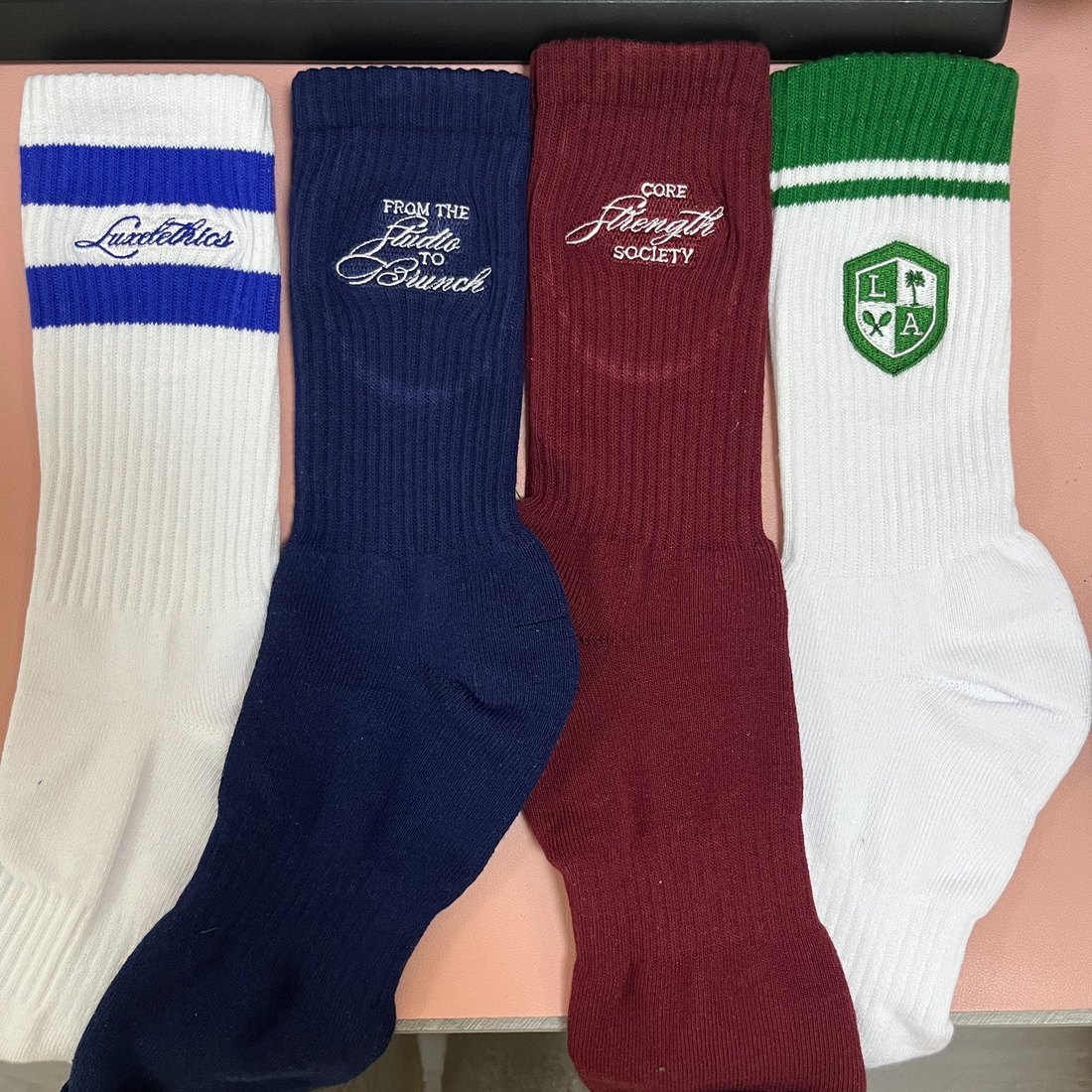 Four pairs of socks lying flat on a warehouse floor in an unlit supplier photograph