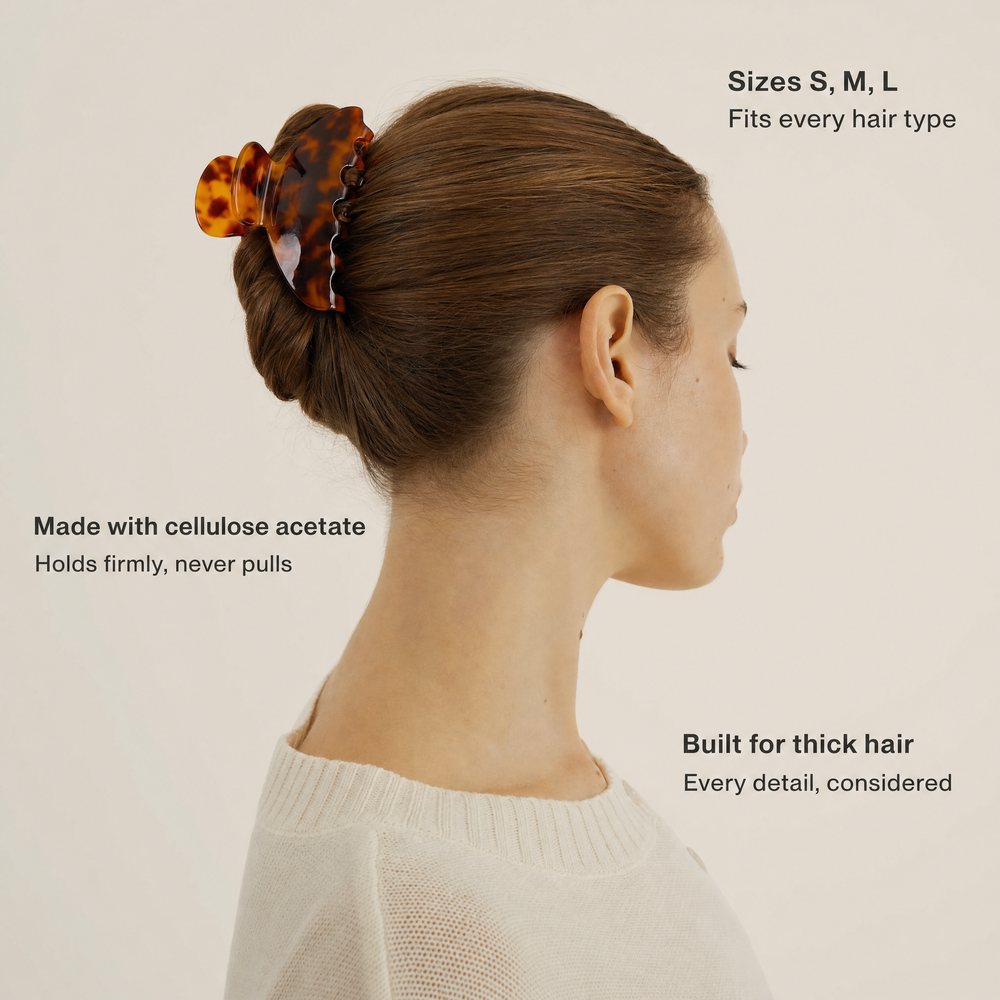 Side profile of a woman with a tortoiseshell claw clip in a French twist, with three text callouts on a cream background